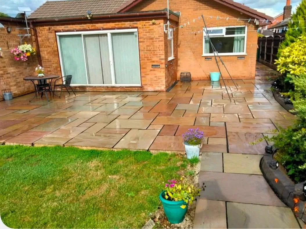 New Indian stone patio across the back of a bungalow with fresh lawn in front