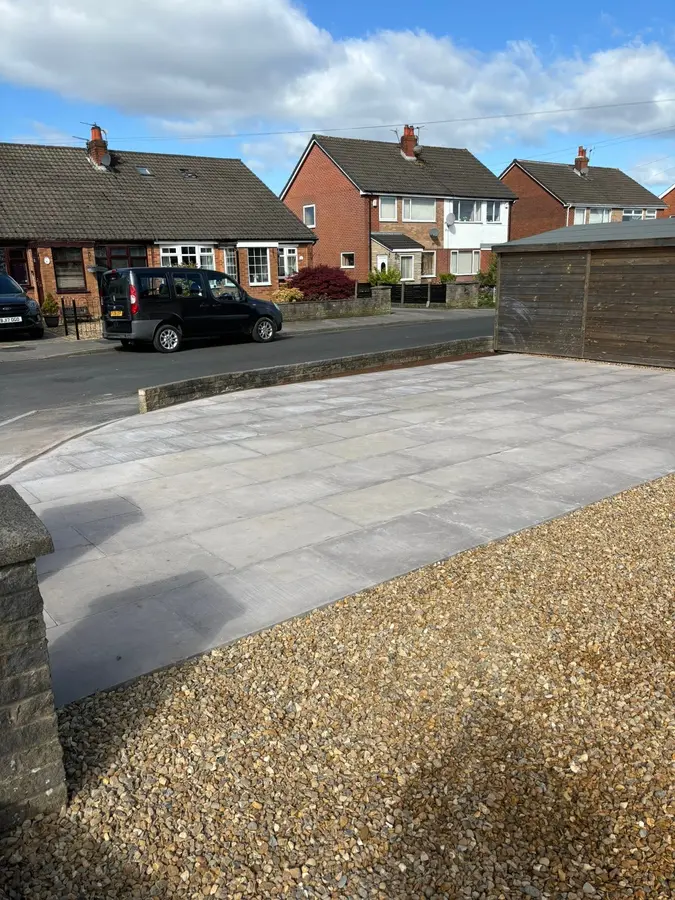 New light grey paved driveway in front of a semi-detached house with a gravel border