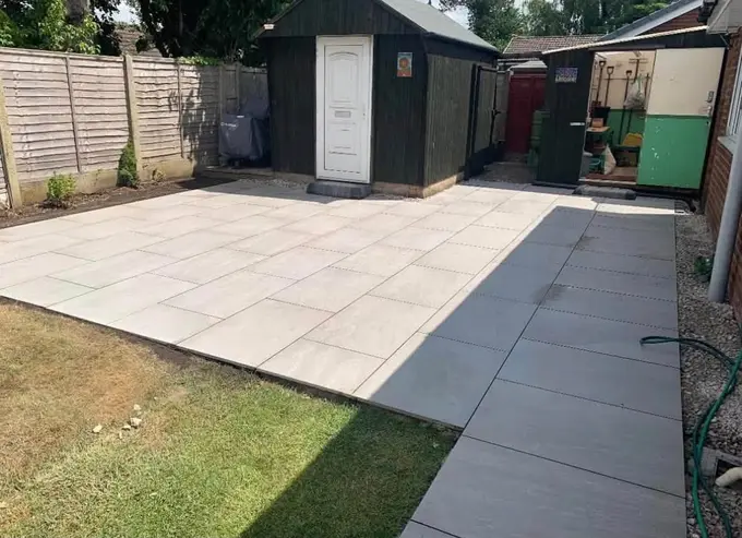 Large porcelain patio leading to a garden shed
